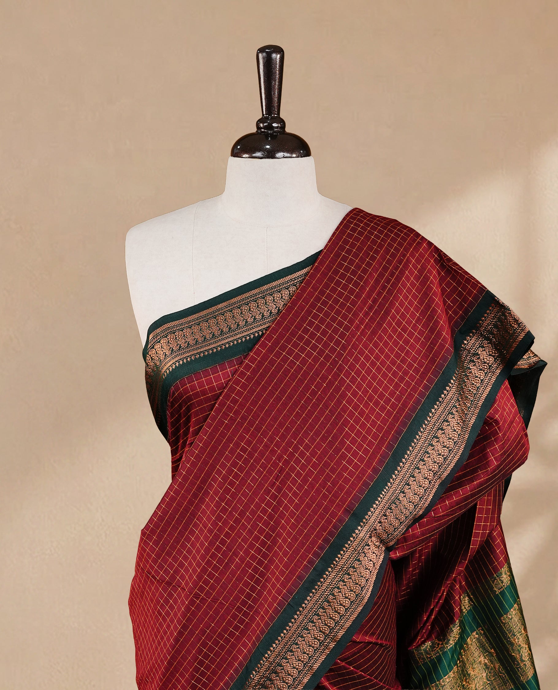 Maroon colour kalyani cotton saree featuring gold zari check pattern on body, complemented by green colour with Antique zari border, paired with matching blouse piece.