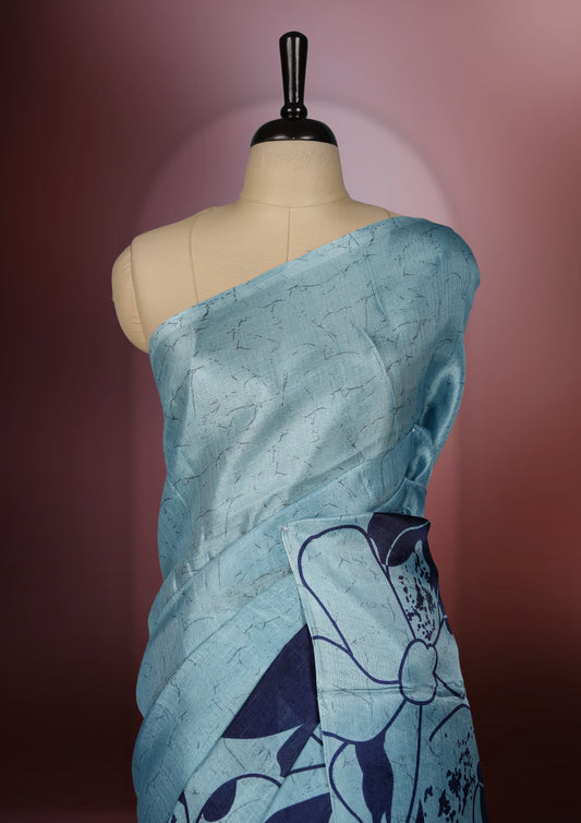 Sky blue colour saree with bold navy floral prints across the body and pallu.,Crafted in soft, lightweight fabric for an elegant drape, Paired with matching blouse.