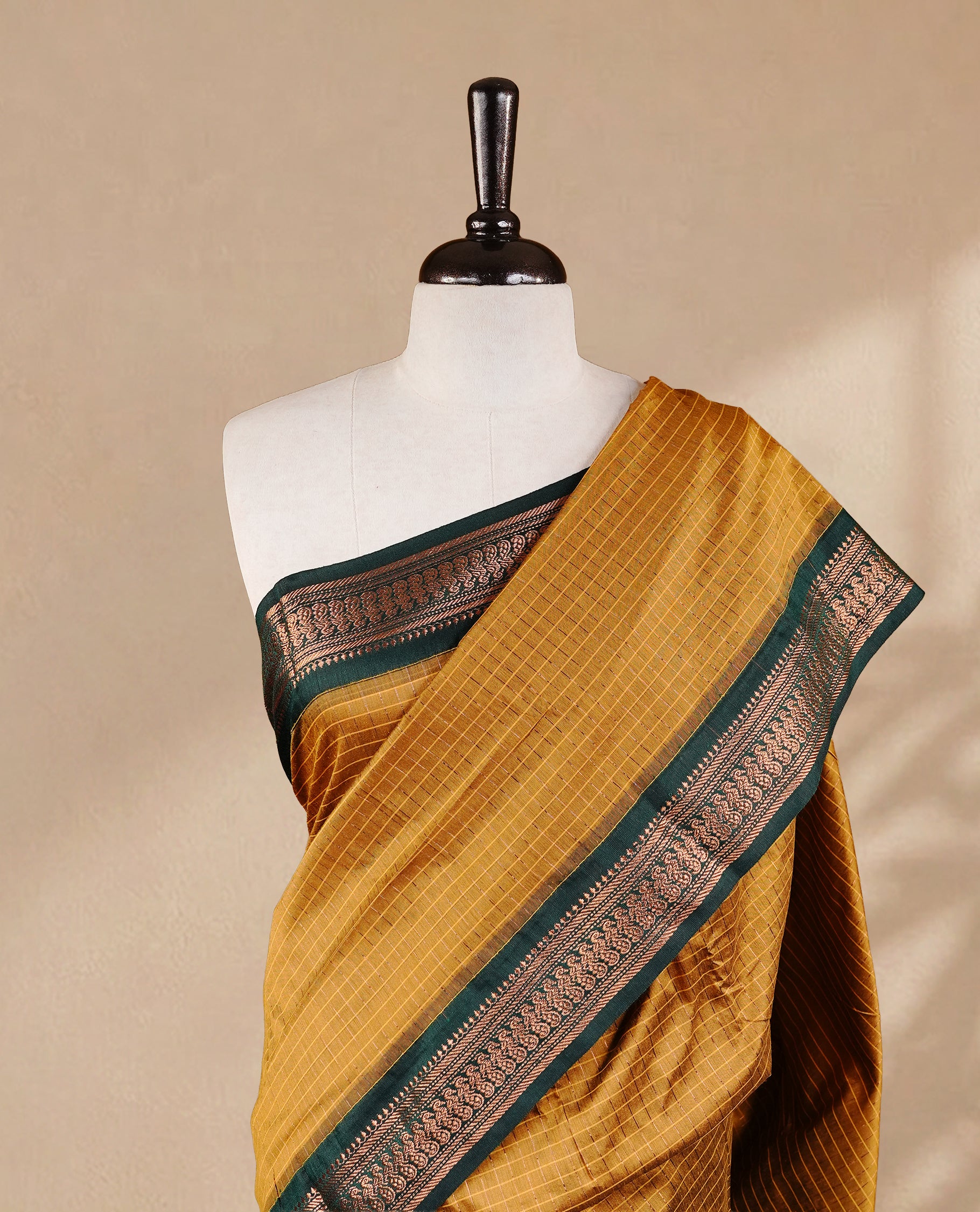 Mustard colour kalyani cotton saree featuring gold zari check pattern on body, complemented by green colour with Antique zari border, paired with matching blouse piece.