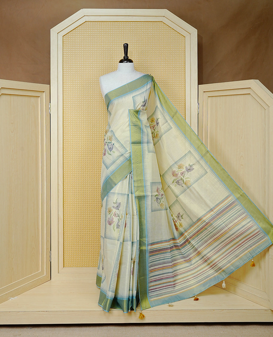 Cream Colour Tissue Kerala Saree Featuring Floral Prints in a Stylish Rectangle Pattern On Body, Enhanced with an Olive Green and Light Blue Zari Border, Multicoloured Striped Pallu Is Finished with Elegant Tassels and Paired with a Matching Blouse Piece.