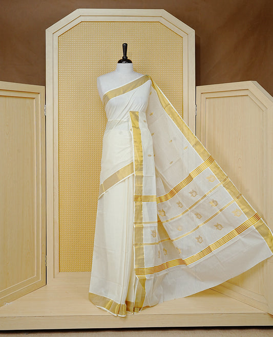 Cream Colour Cotton  Kerala Saree Featuring a Classic Gold Zari Border and Delicate Gold Leafs Motifs Across the Pallu. Finished with Fine Gold Stripes for a Timeless Traditional Look, Paired with a Matching Blouse Piece.