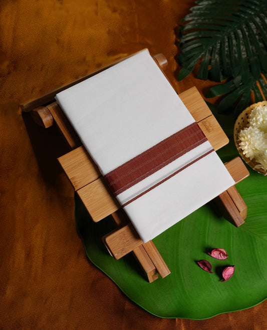 White colour cotton dhoti enhanced with a rust maroon border and fine woven detailing, offering a timeless traditional appeal & Perfect for cultural functions, festive wear, and auspicious occasions.