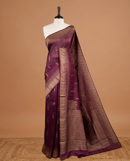 Burgundy colour Semi Banaras Tussar Georgette Featuring Gold zari Leaf pattern on body, Finished with Gold zari border and paired with matching blouse piece.