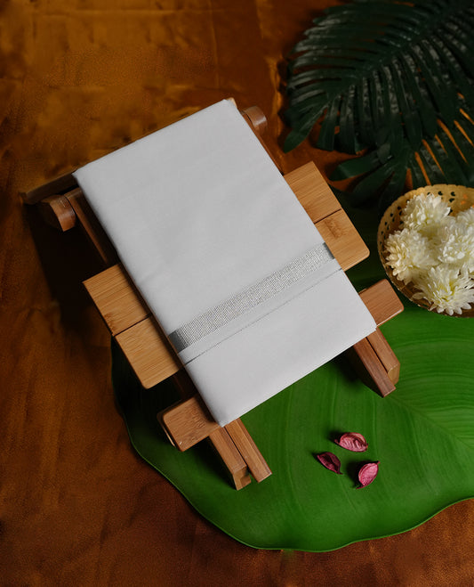 White colour cotton dhoti featuring a refined silver zari border, adding a touch of sophistication and charm & A perfect choice for temple visits, weddings, and traditional festive occasions.