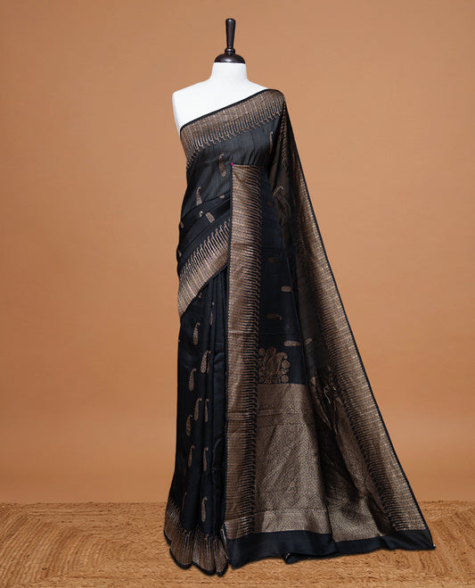 Black colour Semi Banaras Tussar Georgette Featuring Gold zari Leaf pattern on body, Finished with Gold zari border and paired with matching blouse piece.