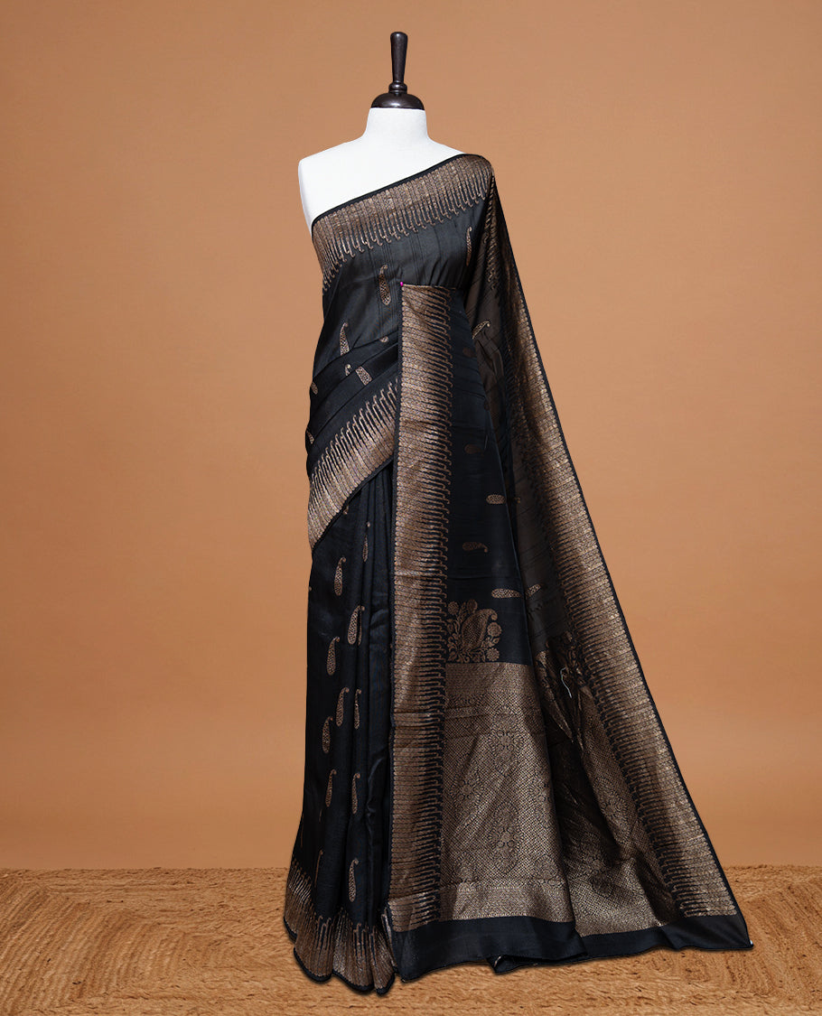 Black colour Semi Banaras Tussar Georgette Featuring Gold zari Leaf pattern on body, Finished with Gold zari border and paired with matching blouse piece.