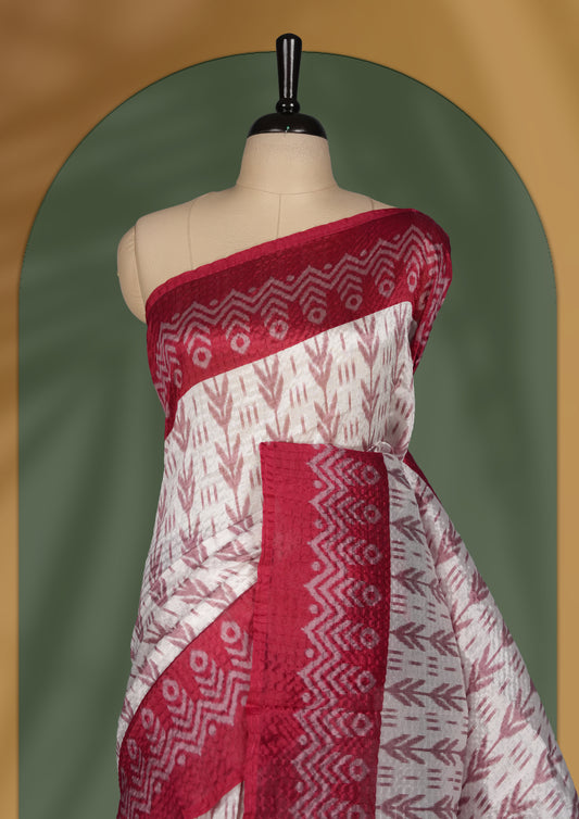 Classic off white colour saree adorned with intricate maroon tribal motifs and rich woven patterns on the pallu and border & Paired with matching blouse.