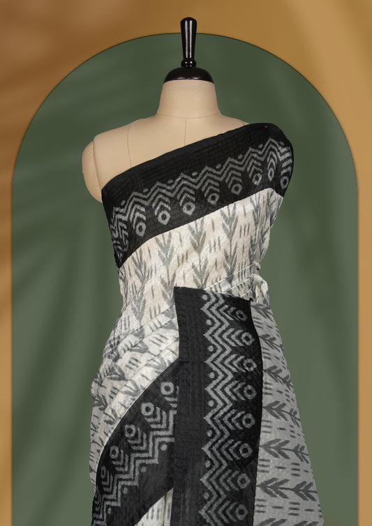 Classic off white colour saree adorned with intricate black tribal motifs and rich woven patterns on the pallu and border & Paired with matching blouse.