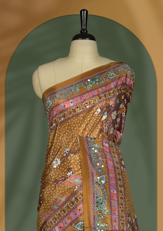 Mustard brown colour saree with intricate multicolor floral and paisley patterns, highlighted by vibrant borders & Paired with a matching blouse.