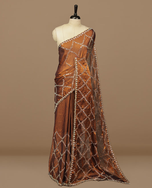 Golden Brown colour designer saree featuring Sequins & cut beats worked body, cut beat worked border, paired with matching unstitched blouse.