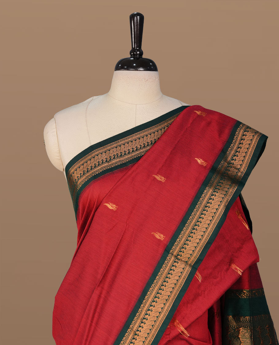 Red colour kalyani cotton saree featuring antique zari motifs on body, complemented by green colour with Antique zari border, paired with matching blouse piece.