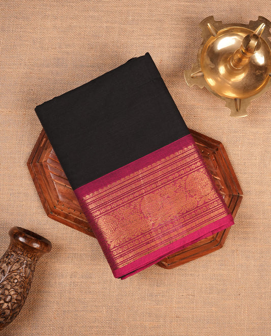 Black colour chettinad cotton saree featuring elegant plain body highlighting contrast magenta colour with gold zari traditional border, pallu and paired with matching blouse piece.