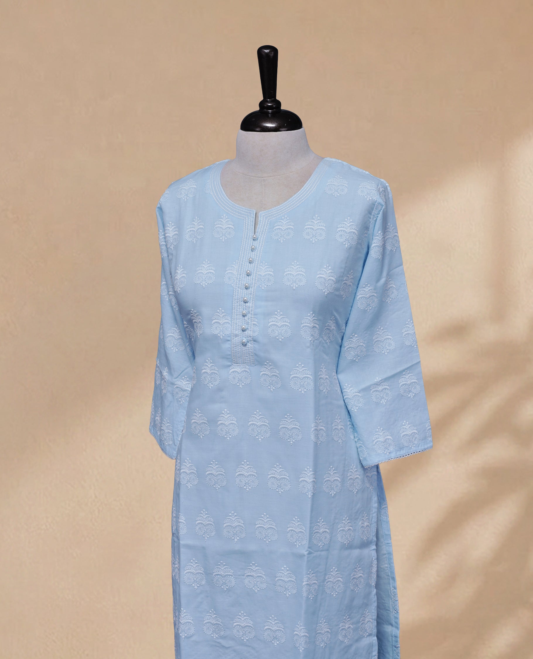 Sky Blue Colour kurti featuring a classic U-shaped Thread Pattern neckline, Beads  &  White Floral Prints on the body, and sleeves.