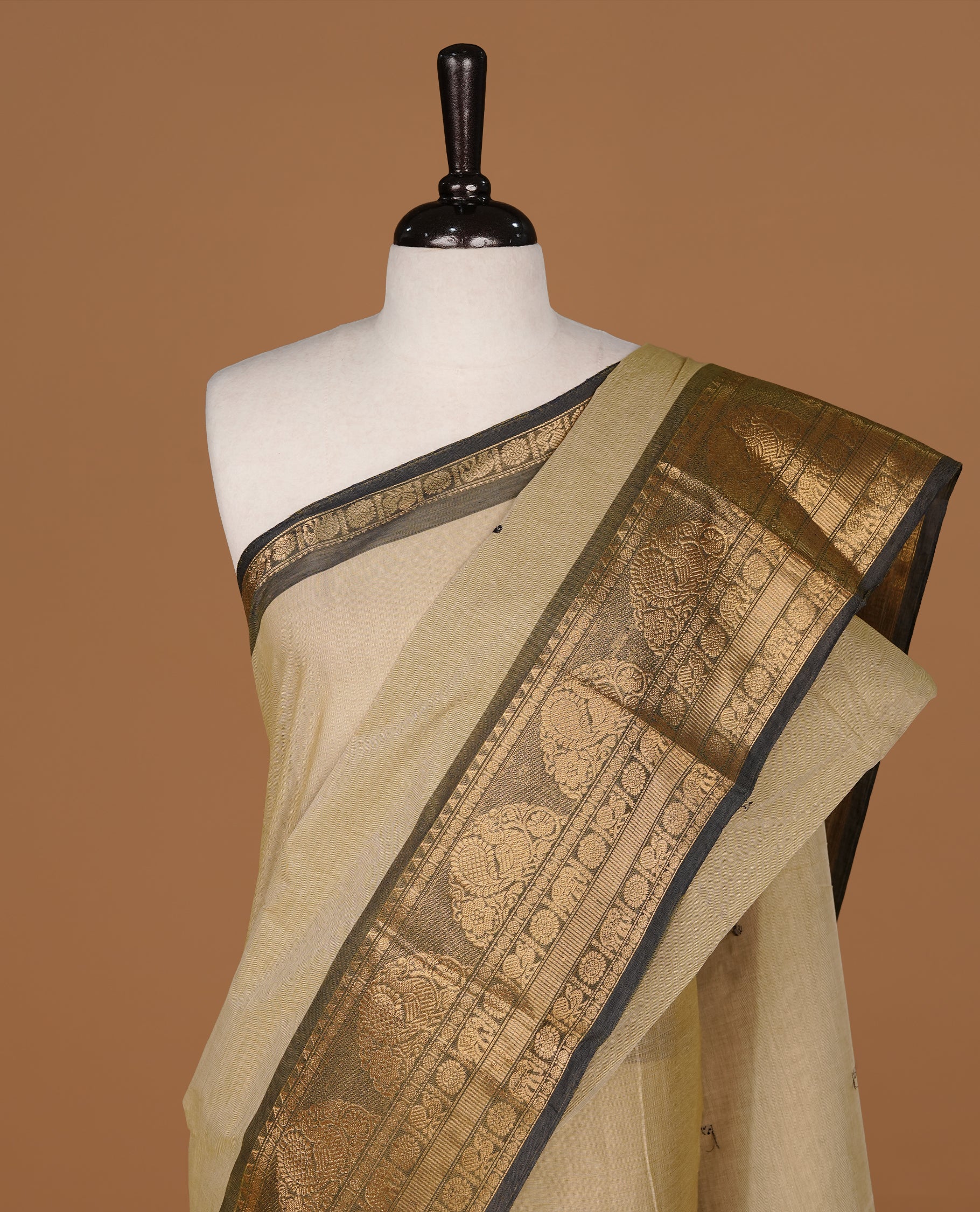 Greyish cream colour Chettinad cotton saree featuring motifs body, complemented by contrast Black colour with gold zari border, paired with matching blouse piece.