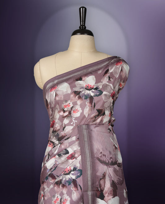 Mauve colour saree adorned with elegant floral prints on the body, enhanced with a subtle matching border, complemented by a beautifully printed pallu featuring blooming flowers, and paired with a matching blouse.