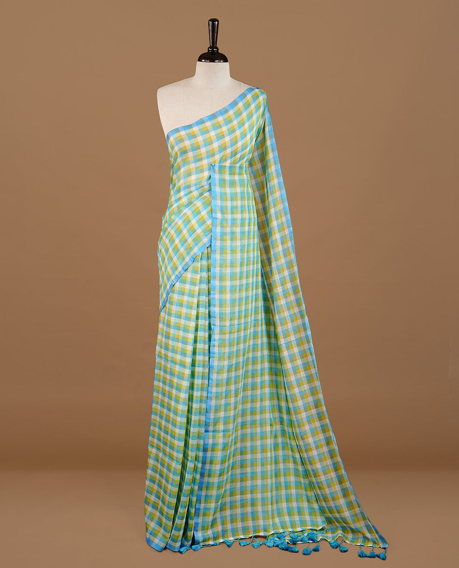 Blue, Green and White colour Mul Cotton saree featuring a classic Big check pattern on the body, accented with tassels for added charm. Comes without a blouse piece.