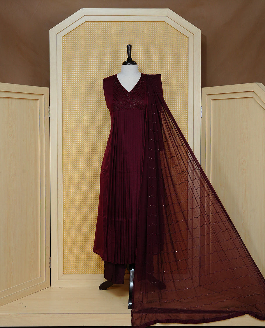 Dark maroon colour churidar set with bead & thread embroidery on the V-neckline, paired with a matching embellished dupatta and solid pants.