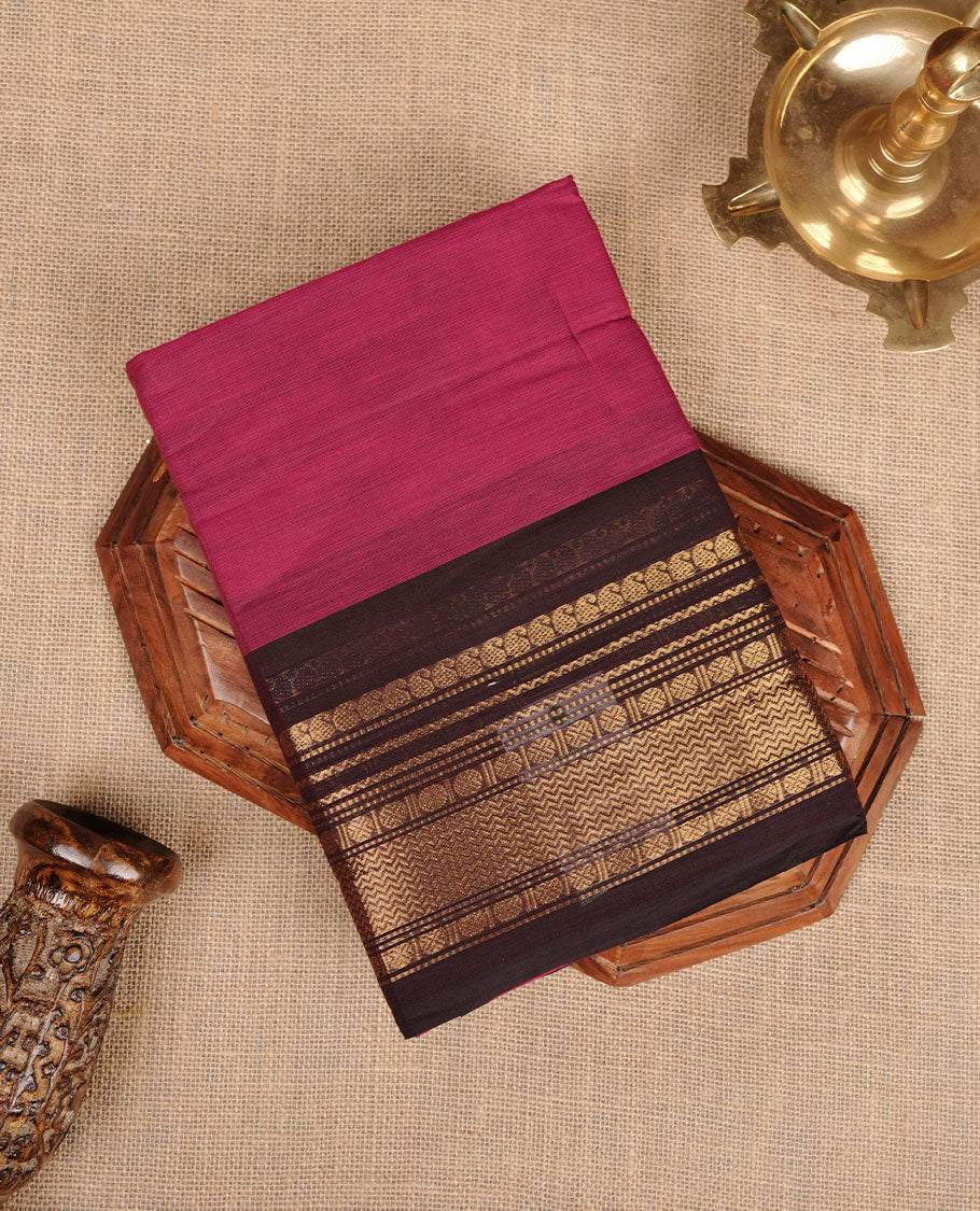 Dark Magenta colour chettinad cotton saree featuring plain body, contrast Dark brown colour with traditional gold zari border paired with matching blouse.