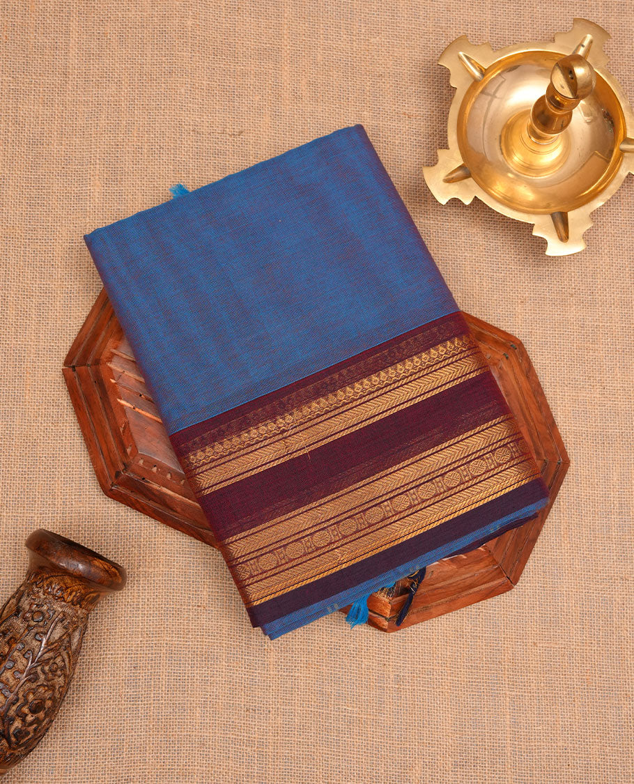 Blue colour chettinad cotton saree featuring Elegant body, contrast purple colour border with gold zari border, pallu and paired with matching blouse.