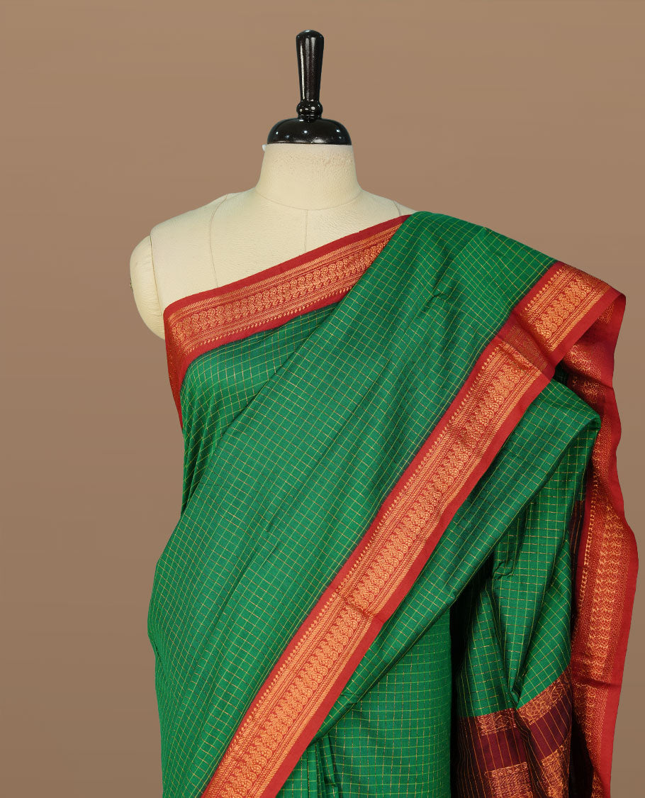 Green colour kalyani cotton saree featuring gold zari check pattern on body, complemented by Maroon colour with Antique zari border, paired with matching blouse piece.