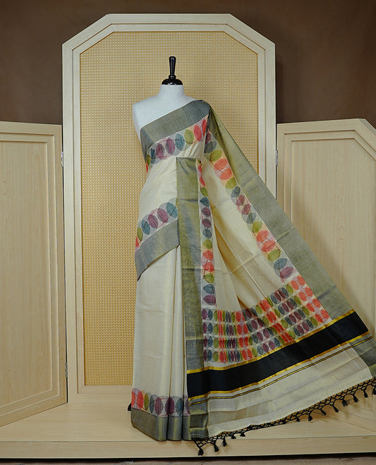 Cream Colour Tissue Kerala Saree Featuring Multicolour Circular Prints Along The Border And Pallu, Complemented By A Black Border With Traditional Gold Zari Accents, Paired With A Matching Blouse Piece.