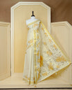 Cream Colour Tissue Kerala Saree Featuring Digital Mustard Yellow Rose Prints Across The Body, Enhanced With A Gold Zari Border , Finished With Light Brown & Cream Tassels And A Matching Blouse Piece