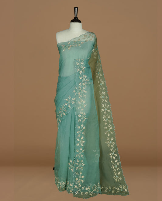 Pastel green colour crush organza saree featuring gold thread floral and stone worked body, highlighting scalp designed border, paired with matching blouse piece.