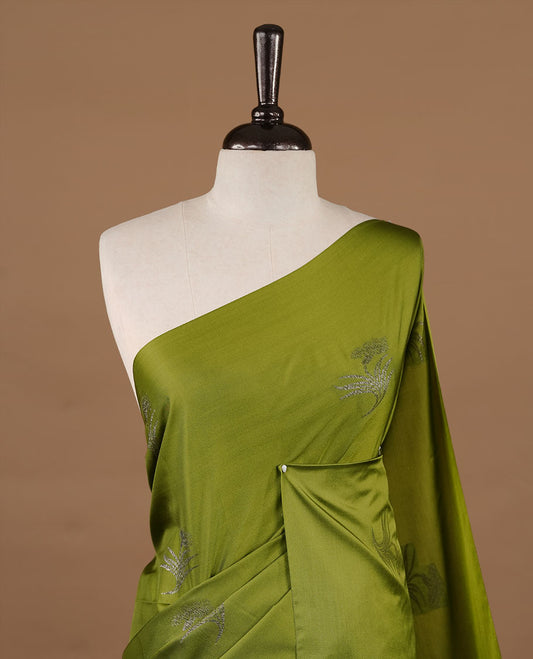 Olive soft silk saree features a sleek borderless design with intricate antique zari motifs, flowing into a seamless self colored pallu and a matching blouse piece.