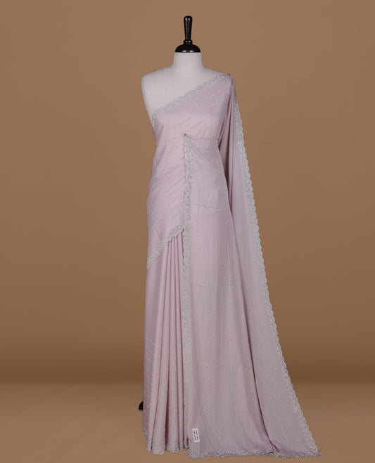 Light pink colour designer saree featuring white stone stripes on body, highlighting white stone with scalp border, paired with matching blouse piece.