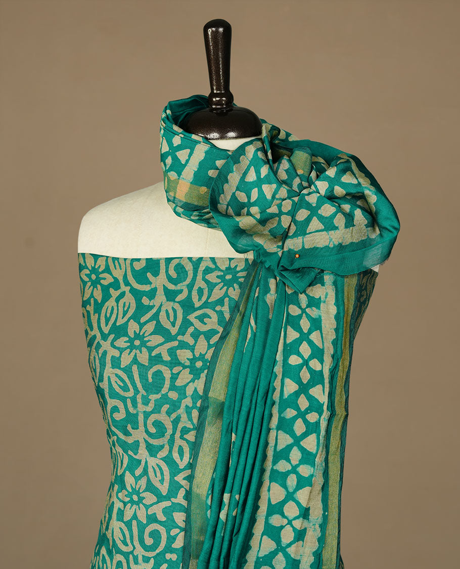 Green colour churidhar material featuring cream colour floral kodi print on body, paired with matching bottom and Dupatta.