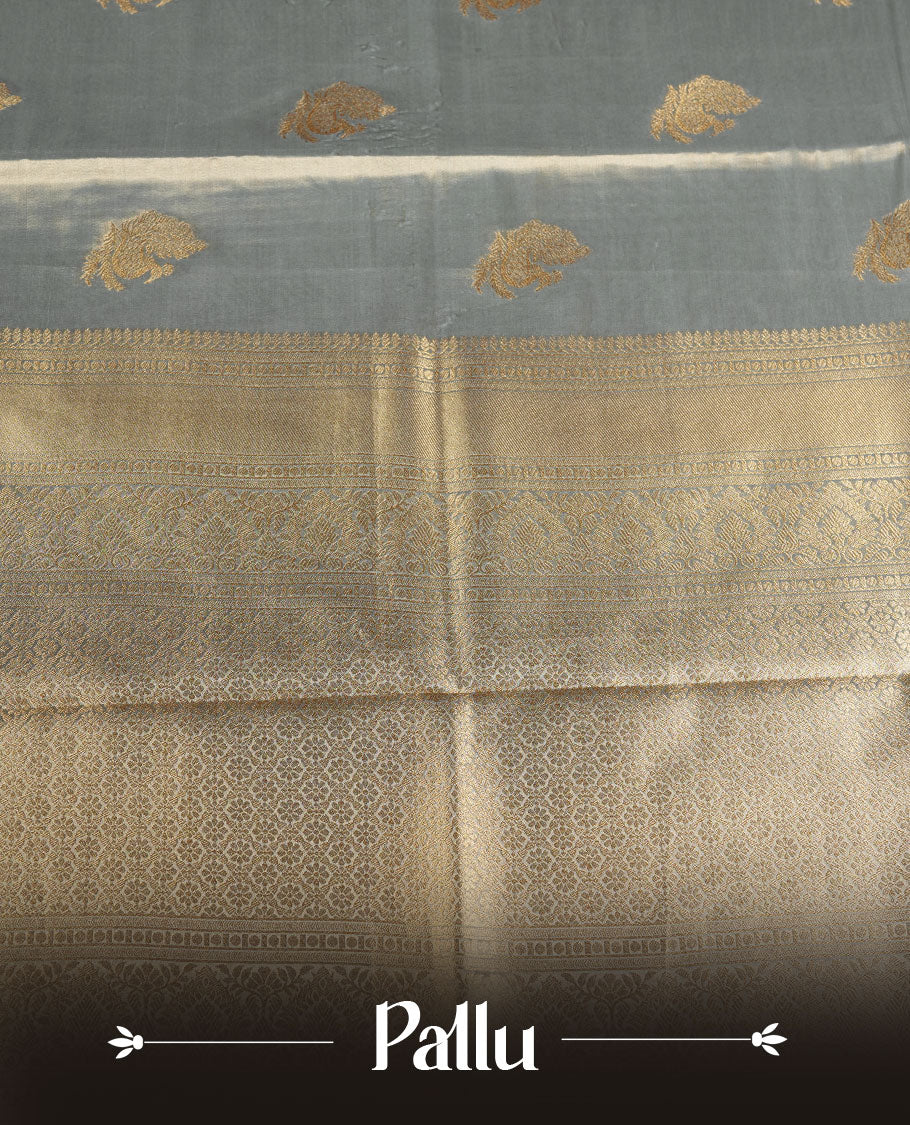Dual tone light blue and gold colour tissue brocade saree featuring antique gold zari motifs on the body with a rich traditional zari border and pallu, paired with a matching blouse piece.