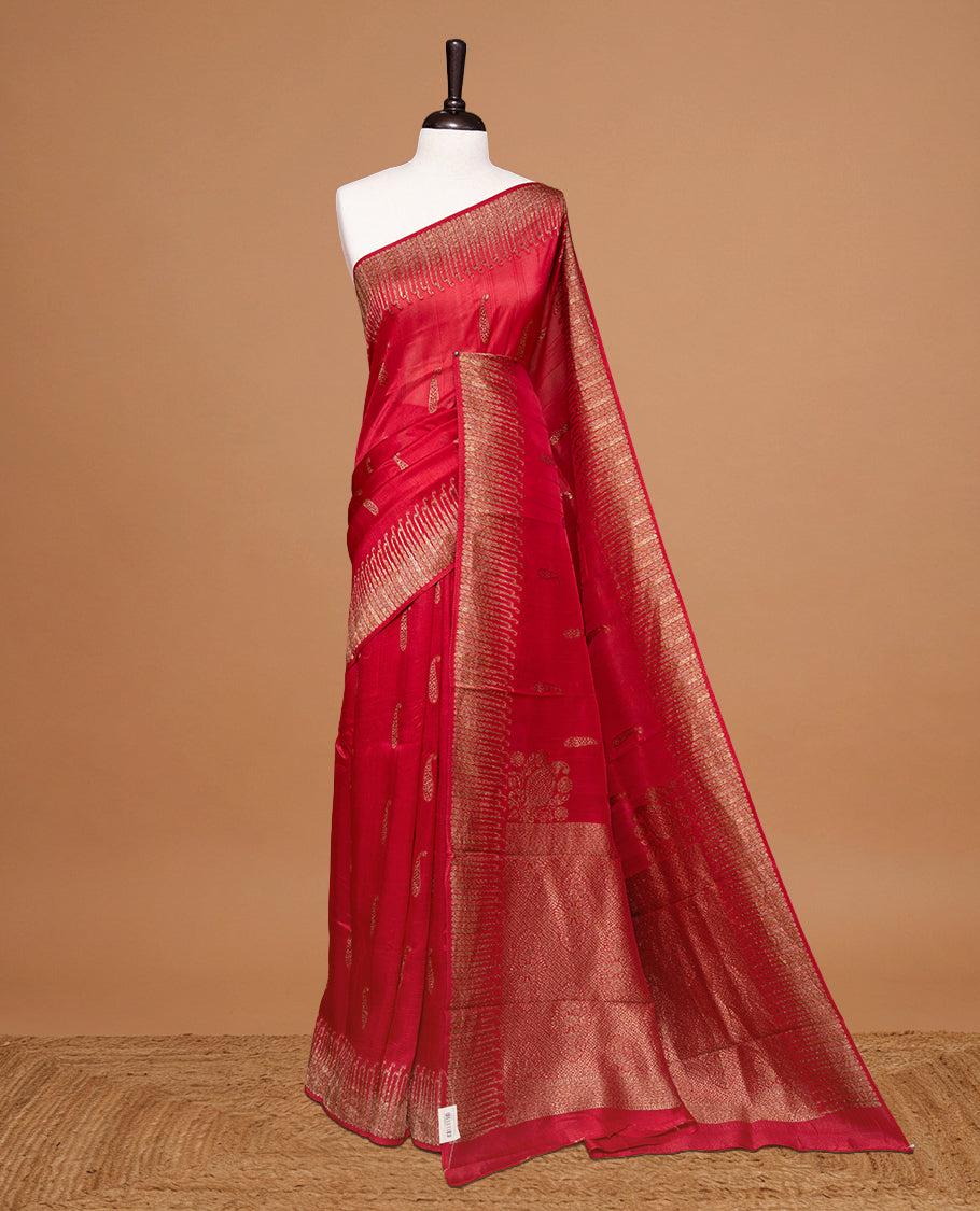 Red colour Semi Banaras Tussar Georgette Featuring Gold zari Leaf pattern on body, Finished with Gold zari border and paired with matching blouse piece.