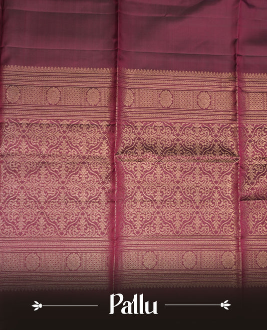 Burgundy colour soft silk saree featuring gold zari motifs on body, complemented by self colour with traditional border with tassel at pallu, paired with matching blouse piece.