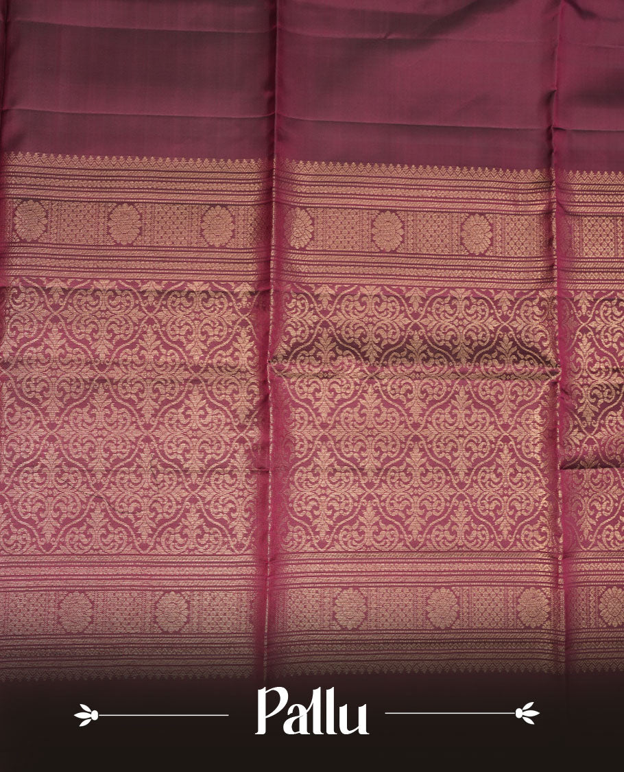 Burgundy colour soft silk saree featuring gold zari motifs on body, complemented by self colour with traditional border with tassel at pallu, paired with matching blouse piece.