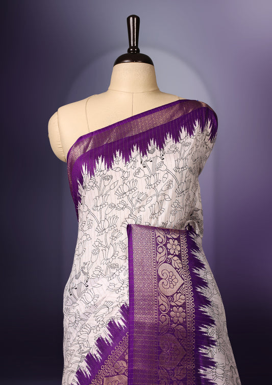 White saree featuring intricate line art motifs all over, elevated with a rich purple and gold zari border & The pallu showcases vibrant multicolor animal and tree designs, paired with a matching blouse.