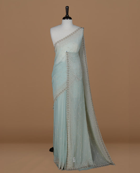 Mint colour designer saree featuring gold & white stone worked body and border, paired with matching blouse piece.
