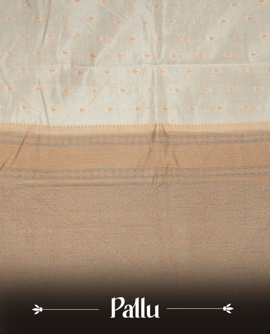 Cream colour tussar saree featuring litte gold zari motifs on body, contrast grey colour border and pallu with zari woven design, comes with matching blouse piece.
