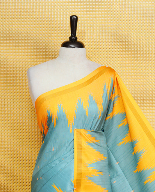 Teal Green And Yellow Colour Kattan silk saree featuring buttas all over the body, a temple-designed border &  a contrasting striped pallu with tassels. Paired with a matching contrast-striped blouse piece.