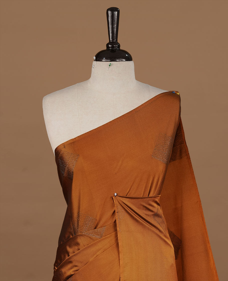Mustard colour soft silk saree features a sleek borderless design with intricate antique zari motifs, flowing into a striking contrast blue pallu and a matching blouse piece.