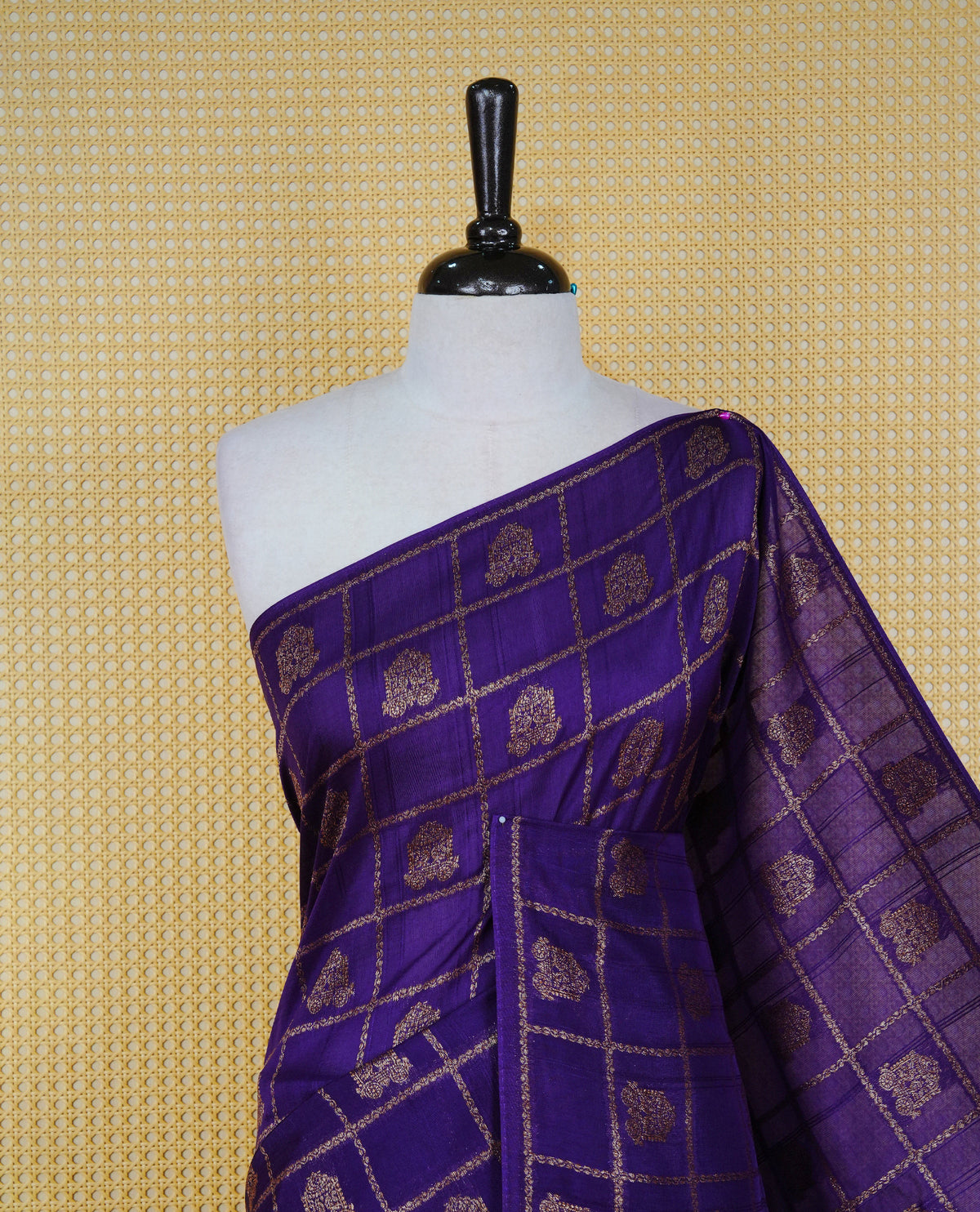 Violet colour semi banaras tussar georgette saree featuring gold zari check with motifs on body, no specific border and paired with matching blouse piece.