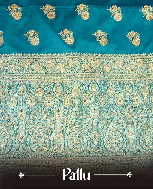 Teal blue colour Banaras Satin Crepe saree featuring gold zari floral motifs on the body, a richly woven traditional border with intricate gold zari detailing, and paired with a matching blouse.