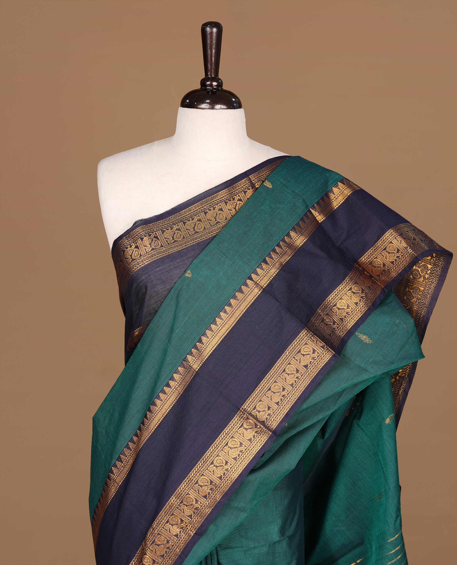Teal green Colour Chettinad cotton saree featuring Gold zari motifs on body , complemented by contrast blue colour with traditional border, comes with matching blouse piece.