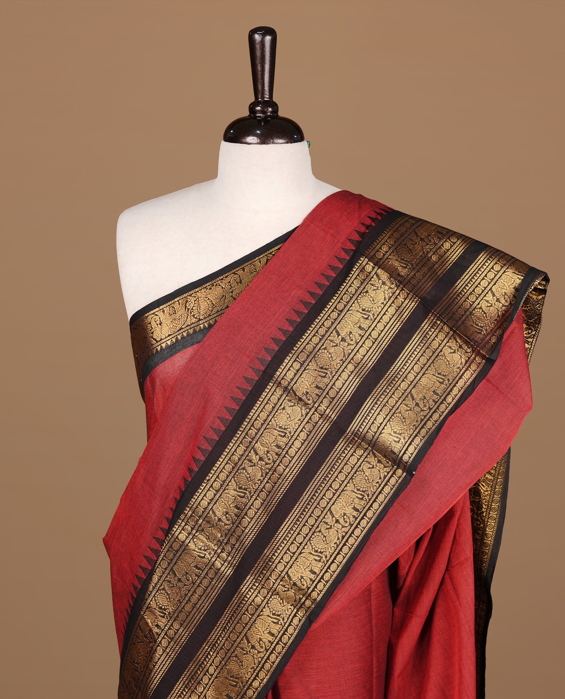 Red colour Chettinad cotton saree featuirng Elegant Plain body, complemented by contrast black colour with gold zari border, paired with matching blouse piece.
