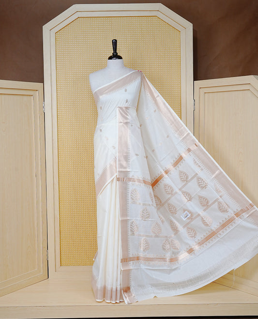 Cream Cotton Kerala Saree with  Gold Zari Leaf Motifs,  Gold Zari Leaf Pattern Border and Pallu, Paired with a Matching Blouse Piece.