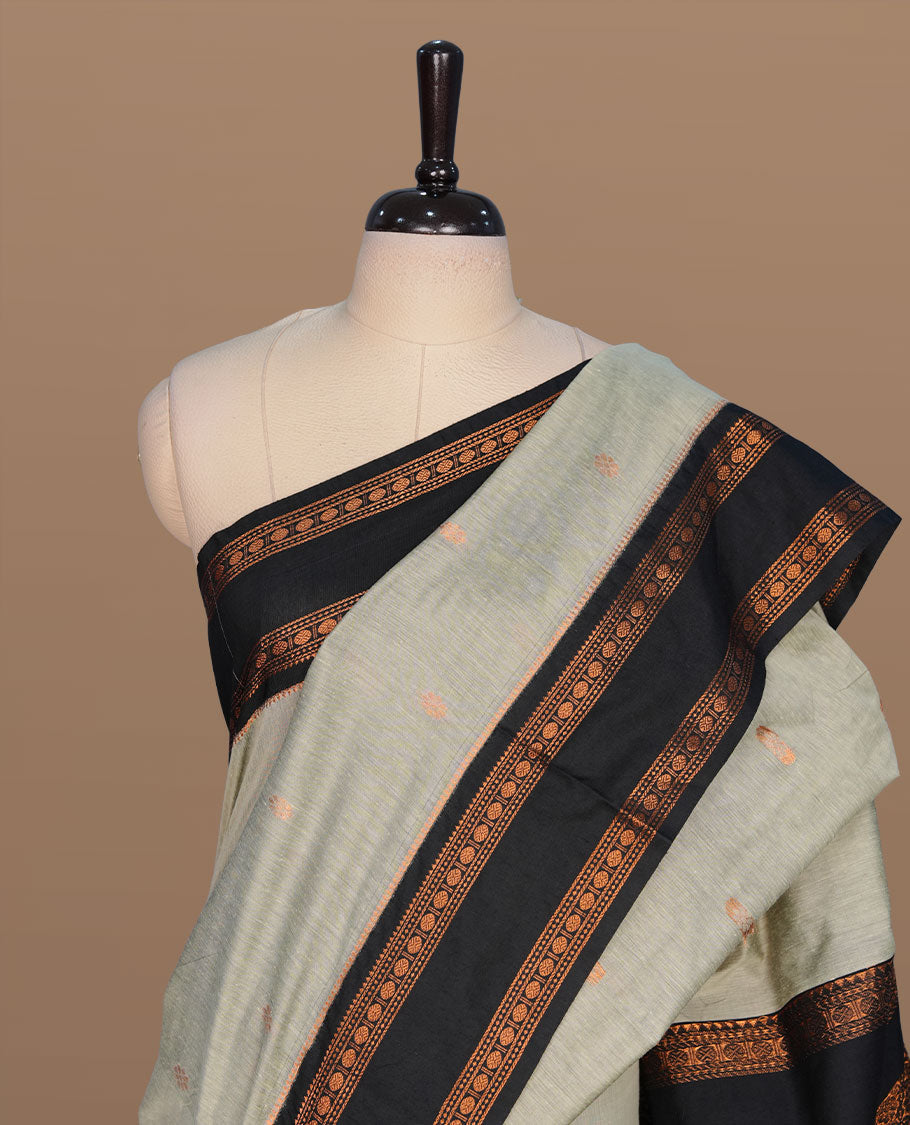 Grey colour kalyani cotton saree featuring gold zari motifs on body, complemented by contrast Black color with copper zari pattern border , paired with matching blouse piece.