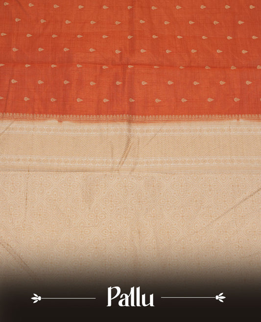Orange colour tussar saree featuring litte gold zari motifs on body, contrast cream colour border and pallu with zari woven design, comes with matching blouse piece.
