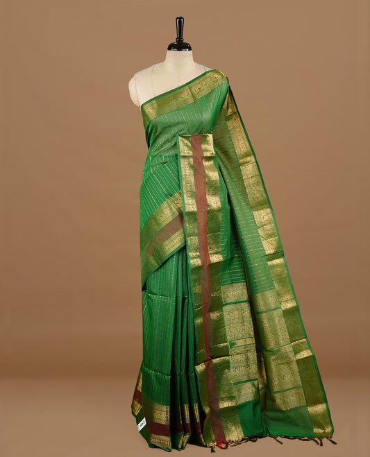 Green colour chettinad cotton saree featuring gold zari stripes on body, highlighting Mixed red colour with zari border, paired with matching blouse piece.