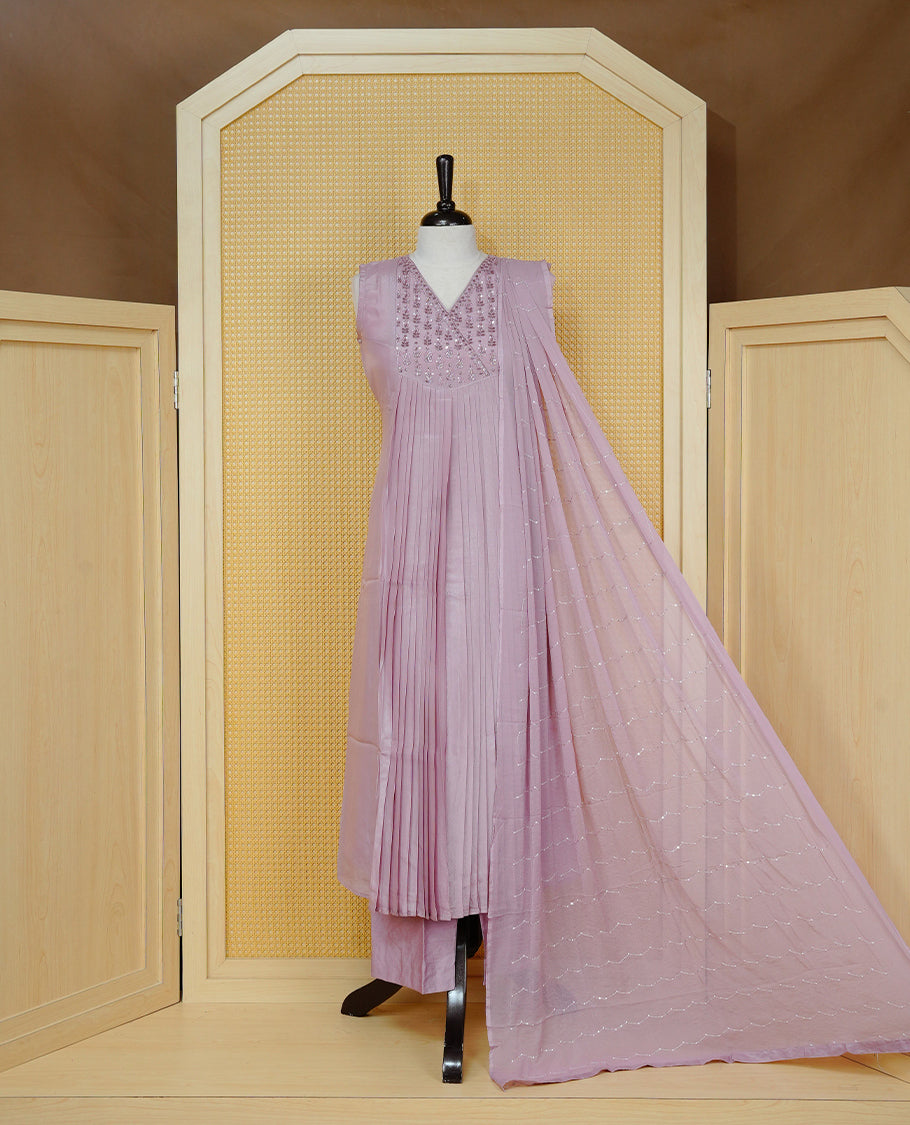 Nude pink colour churidar set with sequins and bead embroidery on the V-neckline, paired with a matching embellished dupatta and solid pants.