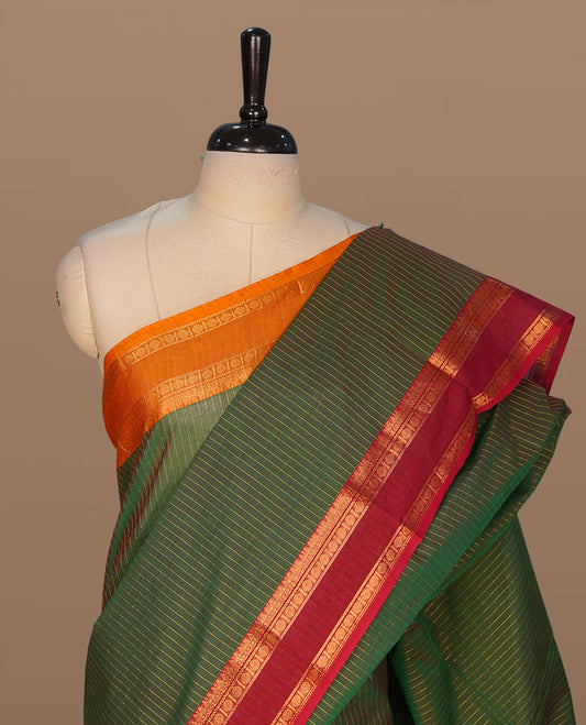 Green colour chettinad cotton featuring gold zari check pattern on body , complemented by contrast Maroon colour with gold zari border, paired with matching blouse piece.
