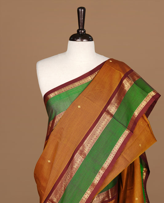 Mustard Olive Colour Chettinad cotton saree featuring Gold zari motifs on body , complemented by contrast Chocolate & Green colour with traditional border, comes with matching blouse piece.